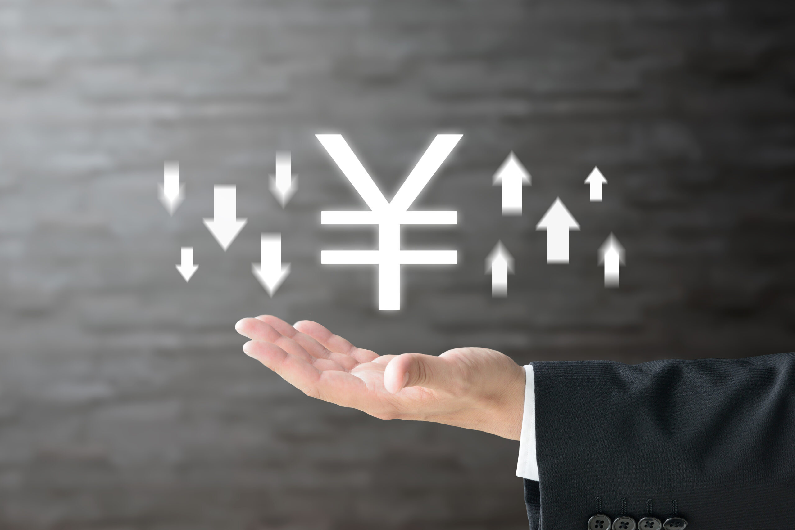 business man’s hand and Japanese yen mark with upward and downward arrows