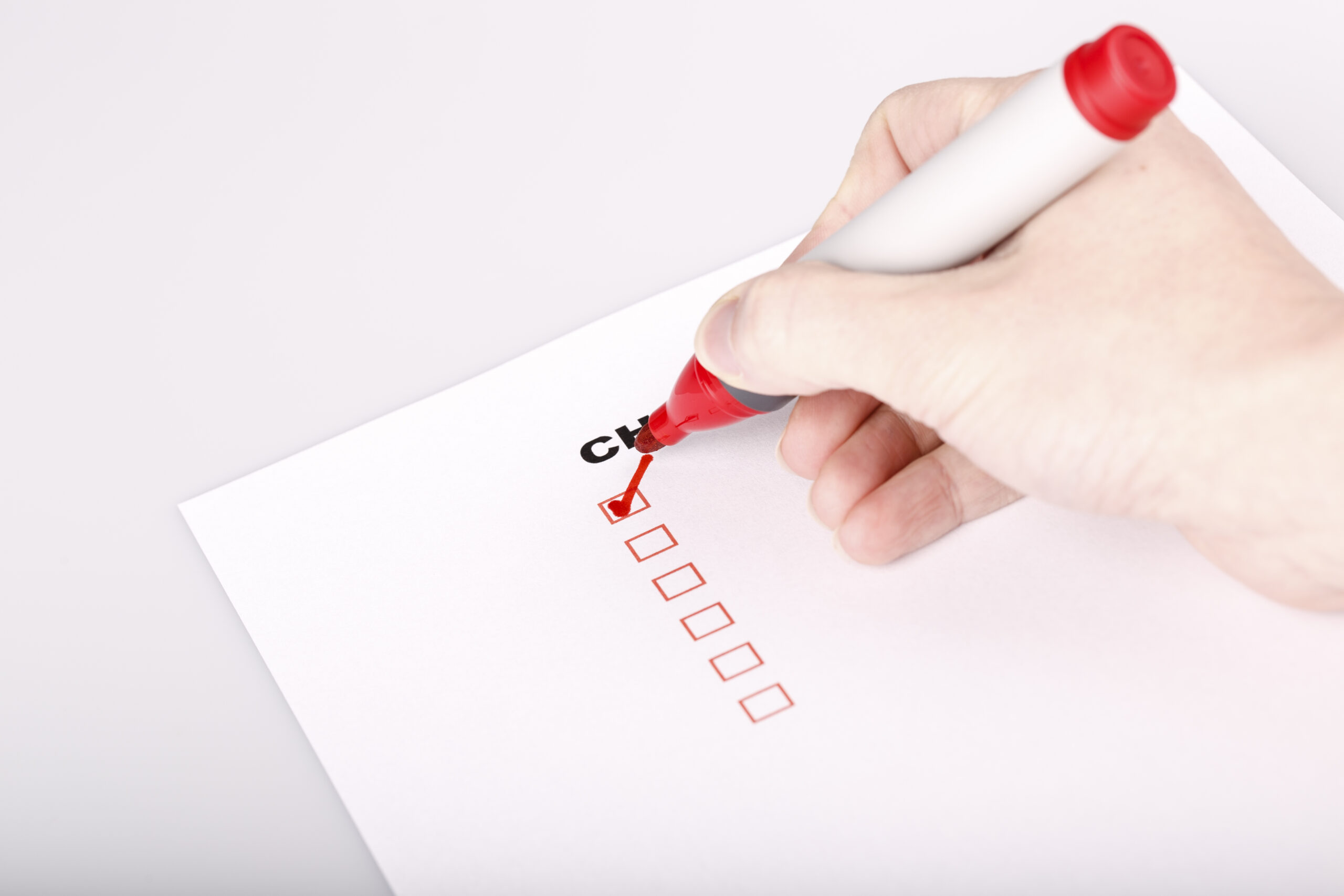 checklist on white with marker and woman hand